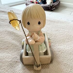 Precious Moments figurine in a wagon.  Wishing you a world of piece